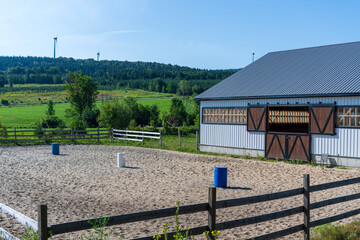 A horse training facility with wind turbines in the background