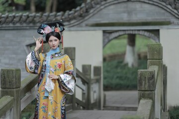 Young woman in traditional clothing posing elegantly in a serene garden setting Chinese word means...