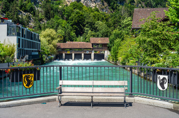 Scenic Aare River View in Interlaken with Bench and Lush Greenery
