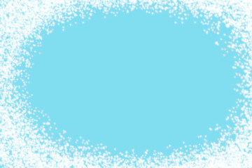 Christmas background with white sparkling snow dots forming an oval frame on a light blue background.