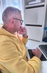 A man sitting at his desk looks at his computer, worried and stressed. Problems at work. Unpaid...