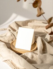 Blank card on a light beige surface, natural light