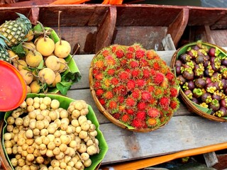 Fresh Tropical Fruits in Baskets at Traditional Thai Floating Market – Rambutan, Mangosteen, Langsat, Sapodilla, and Pineapple Display
