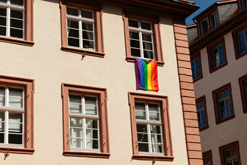 Progress Pride flag hanging from a window of a historic European building