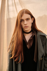 Naklejka premium Stylish redhead man embraces autumn vibes with trendy outfit outdoors