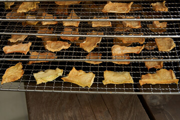 Close-up of dried melon slices on a metal dehydrator rack. Melon chips.