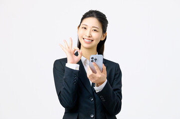 スマホを持ってOKサインするビジネスウーマン