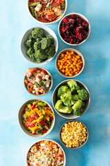Various frozen veggies such as peas, carrots, and beans preserved in plates, a fresh and practical...