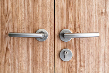 Modern door handles on wooden surface