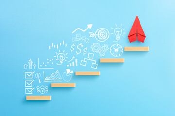 Wooden block stacking as step stair with red paper plane and business strategy on blue background, Ladder of success in business growth concept.