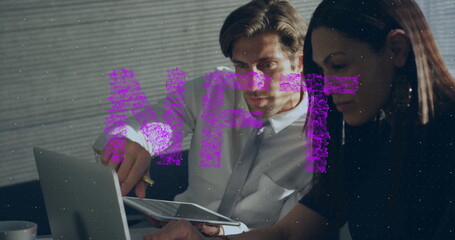 Collaborating mid adult duo reviewing documents with pen at office desk, with laptop and coffee mug