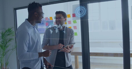 Collaborating coworkers reviewing strategy in meeting room, with glass board notes, tablet stylus