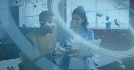 Collaborating two colleagues interacting with holographic interface on laptop in modern office
