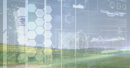 Displaying holographic interface over rural grass field, with hexagon panels and schematics
