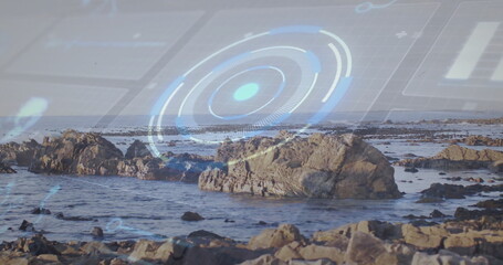 Displaying central rock outcrop with HUD overlay along rocky shoreline, featuring tidal pools