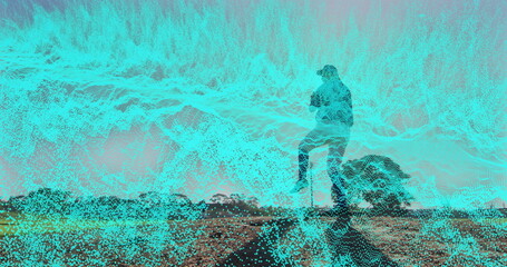 Standing male silhouette holding smartphone on rocky mound, with cyan digital overlay, copy space