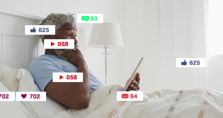 Mid adult man examining tablet, pondering social media numbers in bedroom with overlays, copy space