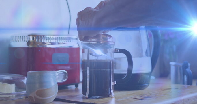 Pressing French press plunger with right hand on wooden kitchen counter, with red toaster - Powered by Adobe
