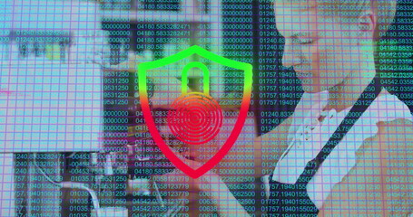 Displaying business professionals analyzing code overlay in office, with laptop and shield icon