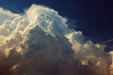 Naklejka premium Majestic clouds billow in the sky creating a dramatic atmosphere during sunset over a serene landscape