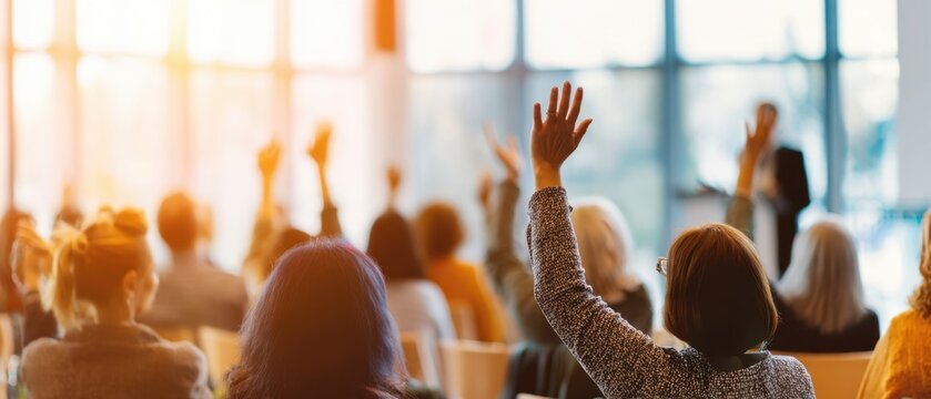 The engaged audience raising hands during a dynamic seminar session