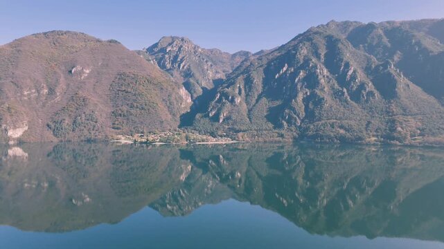 Drone scenery of tranquil lake Idro surrounded by large mountains and Rocca d'Anfo in Italy