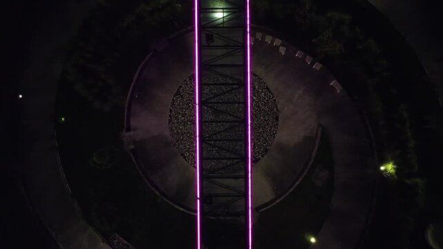 Aerial view of the women's walk in the fundidora park, glowing with neon lights at night near road