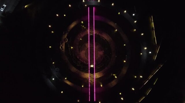 view of the women's walk in the fundidora park, glowing with purple neon lights at night near road