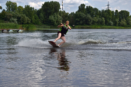 A man is learning to ride a wakeboard.