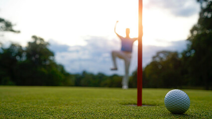 Golfers are putting golf in the evening golf course golf backglound. Golfer hitting golf ball.