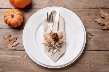 Autumn table setting with pumpkins and maple leaves.