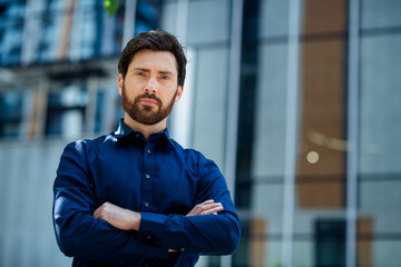 Elegant professional standing outdoors with arms crossed against an urban building background