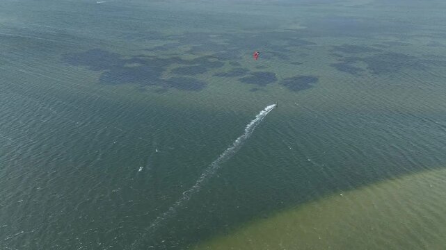 Outer Banks, NC kite surfing across inlet on a warm summer day with dramatic view of clear water