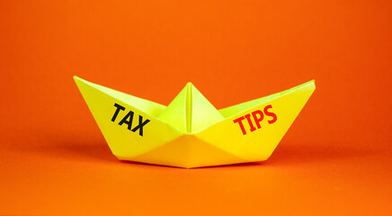 Tax tips symbol. Concept word Tax tips on beautiful yellow paper boat. Beautiful orange paper...