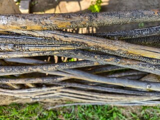 A bunch of wood sticks with some of them burnt. The sticks are arranged in a way that they look like a fence