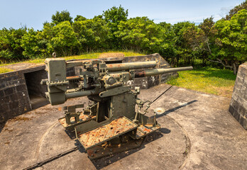 A vintage British 9.4 cm fixed anti-aircraft gun from 1940, located in a coastal fort on Terceira Island, Azores, Portugal. This preserved World War II artillery piece was part of the island's militar