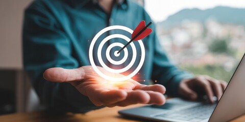 Business Goal - A man's hand holding a glowing target with a dart in the center, symbolizing a clear business goal and strategic focus
