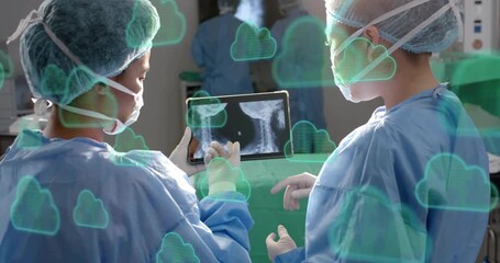 Surgeons hovering hand over tablet initiating health cloud sync of spinal scan for live review - Powered by Adobe