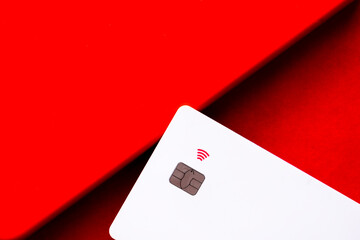 A minimalistic image showing a white payment card with chip technology and a contactless icon...