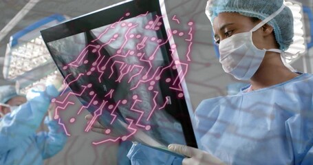 Hospital surgeon lifting X-ray film from tray under OR lights, revealing AI overlay for inspection - Powered by Adobe
