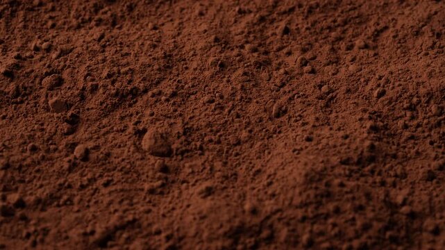 Natural dark brown cocoa powder textured background, close up, rotation. Heap of organic cacao powder