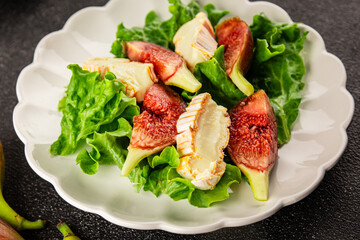 Salad figs, soft cheese, green leaf lettuce tasty snack fresh delicious gourmet food background on...