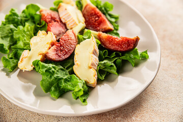 Salad figs, soft cheese, green leaf lettuce tasty snack fresh delicious gourmet food background on the table rustic food top view copy space keto and paleo diet vegetarian food