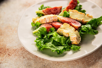 Salad figs, soft cheese, green leaf lettuce tasty snack fresh delicious gourmet food background on the table rustic food top view copy space keto and paleo diet vegetarian food