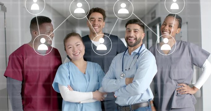 Medical team in hospital hallway watching icons appearing linking over scrubs showing connectivity