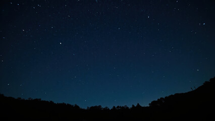 Serene night sky filled with countless stars, creating tranquil atmosphere. dark blue backdrop enhances beauty of celestial bodies