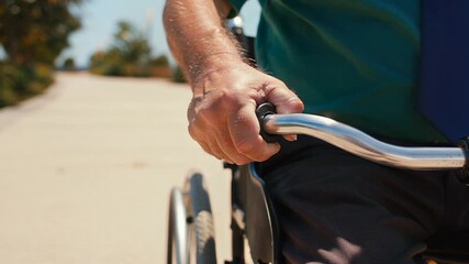 Close-Up of Man’s Hand on Wheelchair Outdoors
