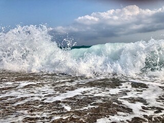 Dynamic ocean waves in motion. Blue ocean waves with white foam and sky