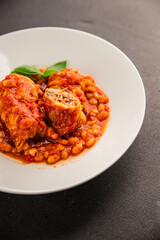 Stuffed cabbage tomato sauce with beans meat, cabbage, fresh delicious gourmet food background on the table rustic food top view copy space
