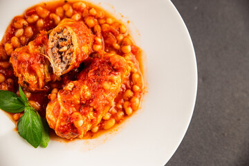 Stuffed cabbage tomato sauce with beans meat, cabbage, fresh delicious gourmet food background on the table rustic food top view copy space